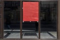 A large empty storefront with a red poster on the glass. Shop for rent