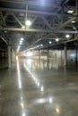 Large empty warehouse inside in industrial building with a high ceiling and artificial lighting Royalty Free Stock Photo