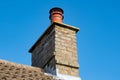 Large, english cottage style brick chimney showing a newly installed terracotta pot. Royalty Free Stock Photo