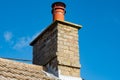 Large, english cottage style brick chimney showing a newly installed terracotta pot. Royalty Free Stock Photo