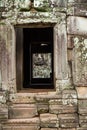 Large ethereal face carved in stone towers seen through stone doorway at the Bayon Temple, Angkor Wat, Cambodia