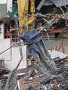 Large excavator demolition claw removing debris and rubble from a wrecked building destroyed by fire Royalty Free Stock Photo