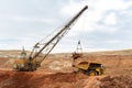 Large excavator loads rock with iron or bauxite mining