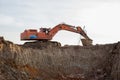 Large excavator working at construction site. Backhoe during earthworks on sand quarry. Earth-moving heavy equipment Royalty Free Stock Photo