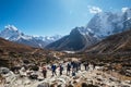 Large expedition members grouon Everest Base Camp trekking route near Dughla 4620m. Backpackers using trekking poles and going by