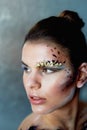 Large-face portrait. Smears on her face. The make-up using dry colors.Creative personality, model.