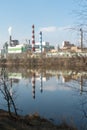 A large factory is located on the river bank. Toxic white smoke escapes from the factory\'s chimneys.