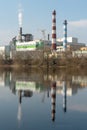 A large factory is located on the river bank. Toxic white smoke escapes from the factory\'s chimneys