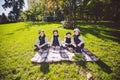 Large family Caucasian children. Three brothers and sister sitting resting on blanket outside the park. Green lawn grass Royalty Free Stock Photo