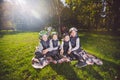 Large family Caucasian children. Three brothers and sister sitting resting on blanket outside the park. Green lawn grass Royalty Free Stock Photo