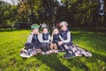 Large family Caucasian children. Three brothers and sister sitting resting on blanket outside the park. Green lawn grass Royalty Free Stock Photo