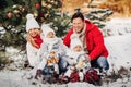 A large family with children at the Christmas tree on the street Happy Children with gifts