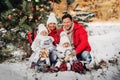 A large family with children at the Christmas tree on the street Happy Children with gifts