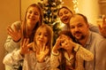 A large family in pajamas is celebrating Christmas at home in the living room. Parents and their three daughters laugh, wave their Royalty Free Stock Photo