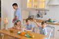 Large family with teenage children eating breakfast in kitchen. Caucasian Royalty Free Stock Photo