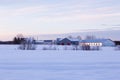 Large farming property with house, barns and grain containers seen during a mauve and pink early spring morning