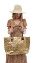 Large female bag of gold color in the hands of a woman in a brown dress isolated on a white background Royalty Free Stock Photo