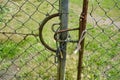 Large fence with wire mesh and barbed wire a chain and a padlock. Grassland, meadow construction site background Royalty Free Stock Photo