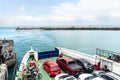 Large ferry boat filled with a variety of vehicles, including cars, motorcycles, and motorbikes