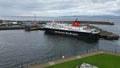 Large ferry boat traversing a harbor on a cloudy day in Ardrossan Marina, Scotland