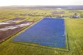 Large field of solar photo voltaic panels system producing renewable clean energy on green grass background