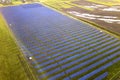 Large field of solar photo voltaic panels system producing renewable clean energy on green grass background