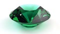 A large, finely cut emerald gemstone with intricate facets on a white surface