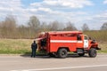 Large fire truck of the rescue service in Russia. Rescuer in a uniform with the inscription Ministry of Emergency