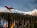 A large firefighting aircraft flies over a forest fire