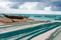 Large fishing nets lying on african beach with boats near the shore