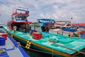 A row of modern large fishing vessel boat boats with deck docking nearby the fish market at Male Maldives