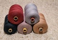 Large five spools of thread lie on top of each other on a white background