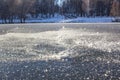 Large flakes of snow on the first clear ice on the river. Beautiful sunny winter morning in the park Royalty Free Stock Photo