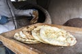 Large flat freshly baked tortillas lie on the table. Hot bread. Central Asian cuisine. aged man makes traditional bread