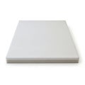 A large, flat, rectangular, white foam mattress resting on a white background Royalty Free Stock Photo