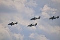 Flying combat aircraft against the blue sky with clouds on a sunny day