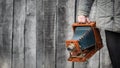 Large format retro camera in photographer hand. Concept - photography of the 1930s-1950s. Retro wooden wall on background, Royalty Free Stock Photo