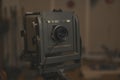 Large format view camera with vintage lens and shutter mounted on a studio rail in a soft indoor setting Royalty Free Stock Photo