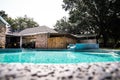 A large free form gray grey accent swimming pool with turquoise blue water in a fenced in backyard in a suburb Royalty Free Stock Photo