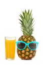 A large fresh ripe pineapple fruit in sunglasses with pineapple juice on a white isolated background. summer fruit