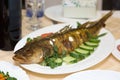 Large fried fish on a platter with vegetables