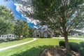 Large front yard with a large gray craftsman new construction house with a landscaped yard and leading pathway sidewalk