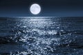 Large Full Blue Moon Rises Brightly Over a Calm Ocean Scene Royalty Free Stock Photo