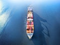 Large full loaded container ship sailing high seas. Aerial front view