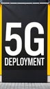 Large 5G Deployment announcement banner with white text hanging on an exterior wall Royalty Free Stock Photo