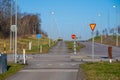 Large gang of industrial workers walking along a bike path by a road..