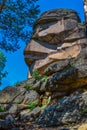 Large geometric stone rocks form of face profile in light of sun. Krasnoyarsk pillars, nature park in Siberia. Blue sky