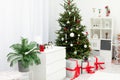 Large gifts lying under a decorated Christmas tree in a bright room Royalty Free Stock Photo