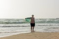 A large girl walks along the edge of the water