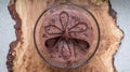 Large glass bowl of chocolate mousse standing on an olive wood platter, decorated with chocolate shavings and curls.